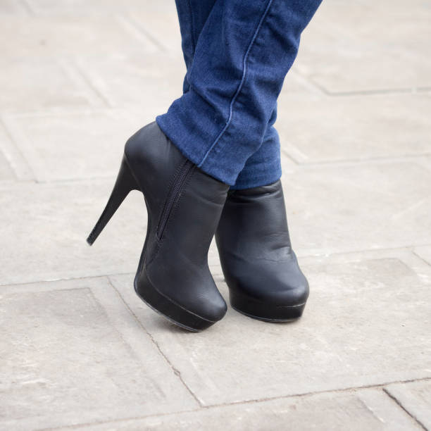 istock Girl's leg with black boots on a high heel. 1427621904
