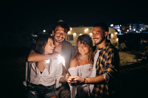 istock Friends at night on the beach with sparklers. 1427622085