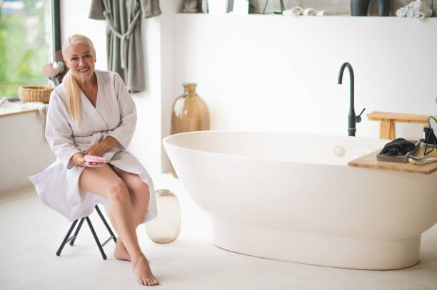 istock Barefoot woman in the bathrobe preparing for lymphatic drainage self-massage 1427623263