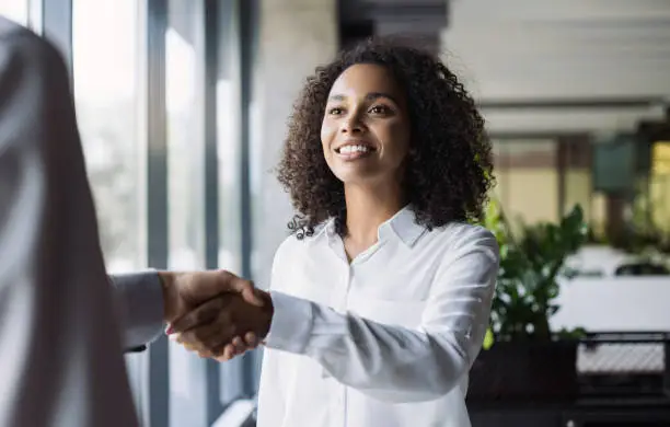 Photo of Young business people shaking hands in office. Finishing successful meeting