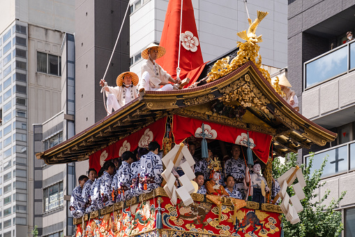 Kyoto, Japan - July 17, 2022: Men sitting on a float that goes around in the city during the Gion Matsuri parade in Kyoto.