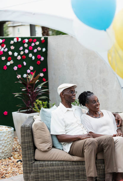 couple de personnes âgées assis ensemble sur un canapé-terrasse, souriant - senior adult comfortable relaxation latin american and hispanic ethnicity photos et images de collection