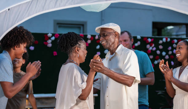 istock Senior couple slow dancing, surrounded by family 1427633322