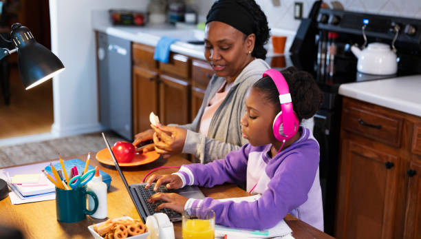 dziewczyna korzystająca z laptopa w kuchni, babcia obserwująca - grandparent using computer laptop dining table zdjęcia i obrazy z banku zdjęć