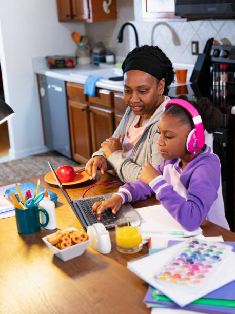 girl using laptop in kitchen, grandmother watching - grandparent using computer laptop dining table imagens e fotografias de stock