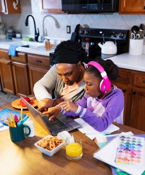 girl using laptop in kitchen, grandmother helping - grandparent using computer laptop dining table imagens e fotografias de stock