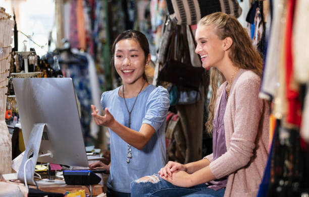 dos empleados de ventas multirraciales en la tienda al momento de pagar - department store shopping teenage girls clothing fotografías e imágenes de stock