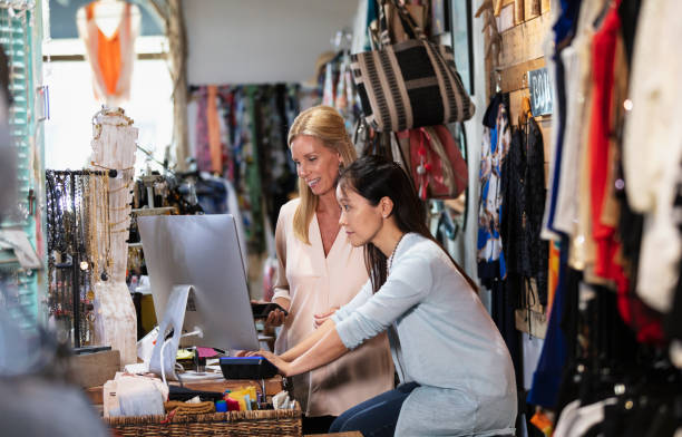 istock Two women working at checkout in clothing store 1427635844