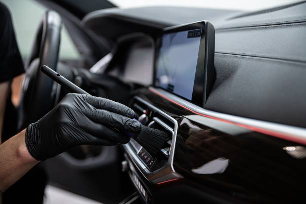 car detailing studio employee carefully cleans the air vents - car cleaning inside of indoors imagens e fotografias de stock