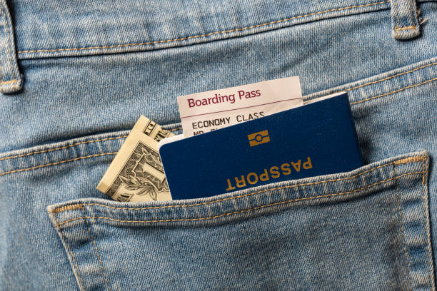 Dollars, blue passport and boarding pass in your pocket jeans, close up, top view Dollars, blue passport and boarding pass in your pocket jeans, close up, top view. Travel concept jeans denim passport pocket stock pictures, royalty-free photos & images