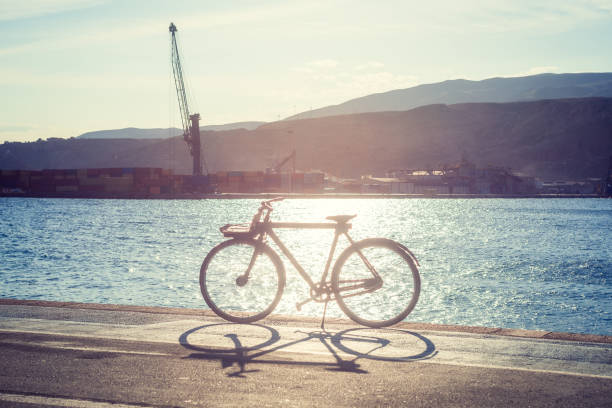 Container loading dock in the harbor with a bicycle in the foreground magically illuminated by sunlight