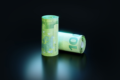 Rolled up 100 Euro banknotes on dark background. Horizontal composition with copy space. Finance concept.