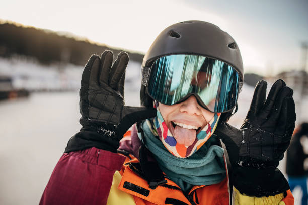 Portrait of a female skier standing on a hill on a snowcapped mountain ski resort.