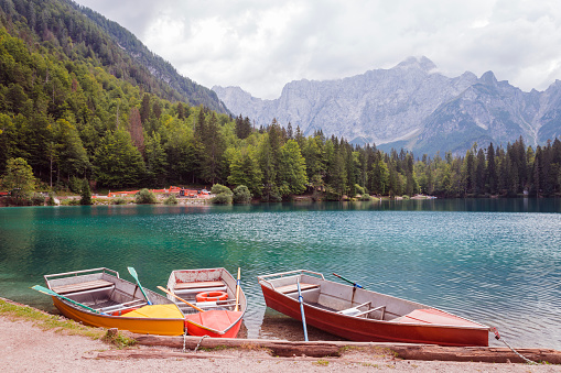 Beautiful Laghi di Fusine in Italy and boats parked on a shore