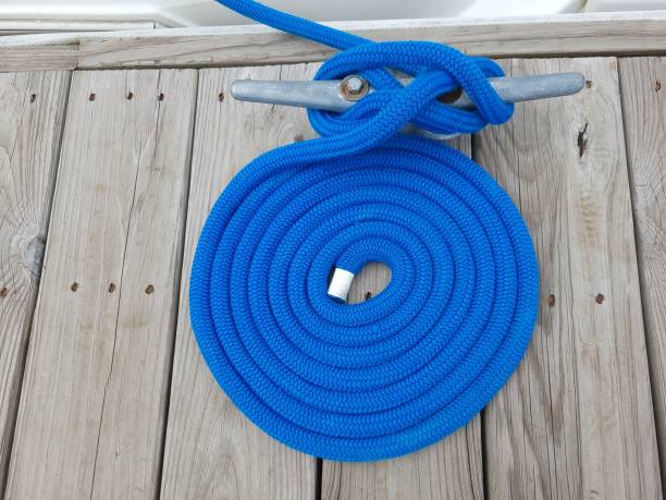 cuerda azul para bote asegurada al taco en el muelle de madera - moored nautical equipment circle rope fotografías e imágenes de stock