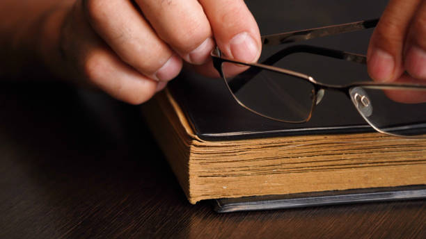 istock A man's hand and an old book on the table 1427650508