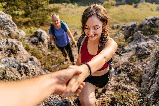 istock Father Helping His Daughter Climb Up The Mountain 1427651881