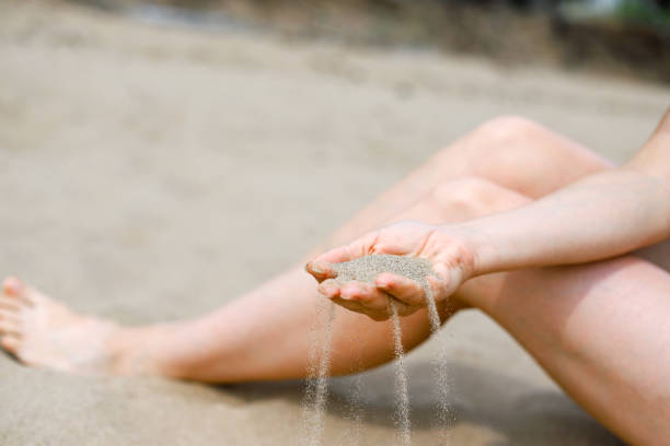 istock Sand falling from woman's hand. Vacation on the beach 1427653916