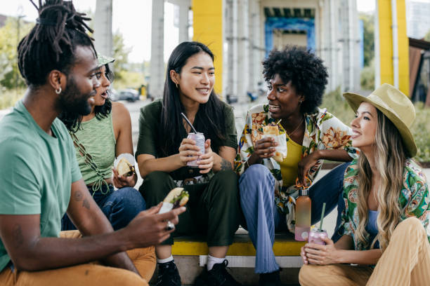 Group of young people having lunch break outdoors stock photo