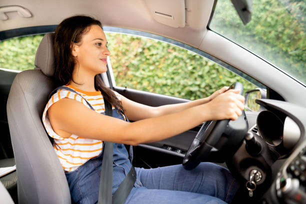 istock Happy young woman driving a car 1427656050