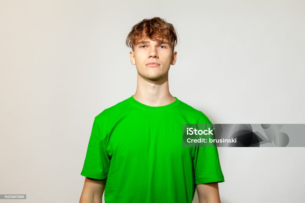Studio portrait of a caucasian young man in a green t-shirt on a white background White Background Stock Photo