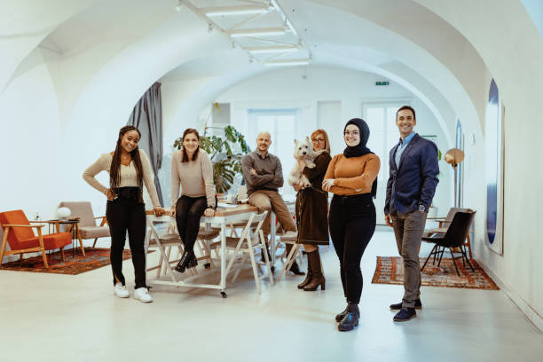 istock Multi ethnic group of entrepreneurs working in pet friendly office looking at camera 1427658336