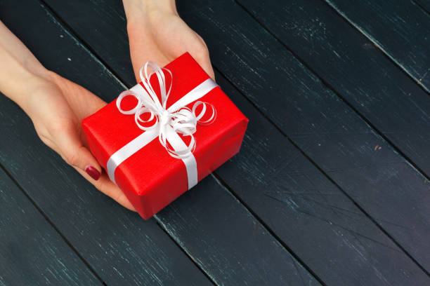 istock gift box in hand girls on wood table 1427658884