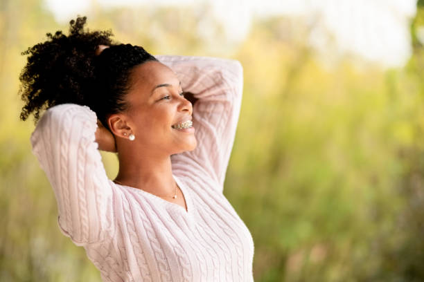 istock Young african woman standing in balcony with hands behind head 1427659825
