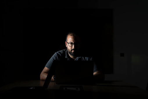 software developer working in dark room