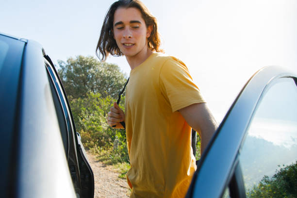 istock Man standing by car against clear sky and trees 1427662012