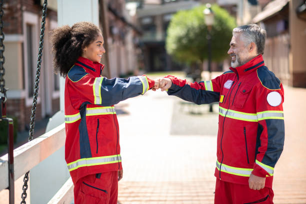 Two joyful paramedics greeting each other outdoors