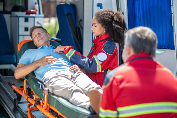 istock Paramedic examining an unconscious man lying down on the stretcher 1427662545