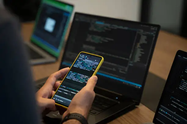 Photo of A programmer who develops software for mobile devices checks the software he has developed on the phone.