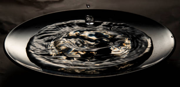 istock Water splash inside a dark metal plate closeup view 1427671588