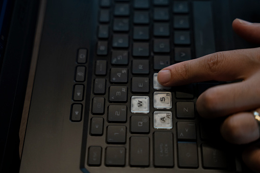 modern laptop keyboard , white color w , a, s , d keys