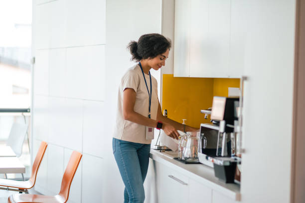 istock Female office worker in the office swithing on a microwave oven 1427678455