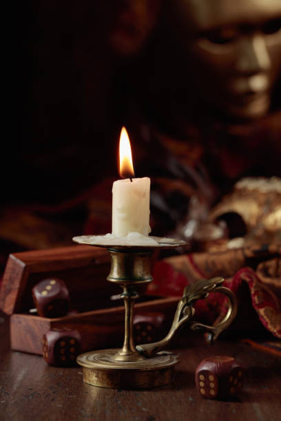 Burning candle, dice, and carnival masks.