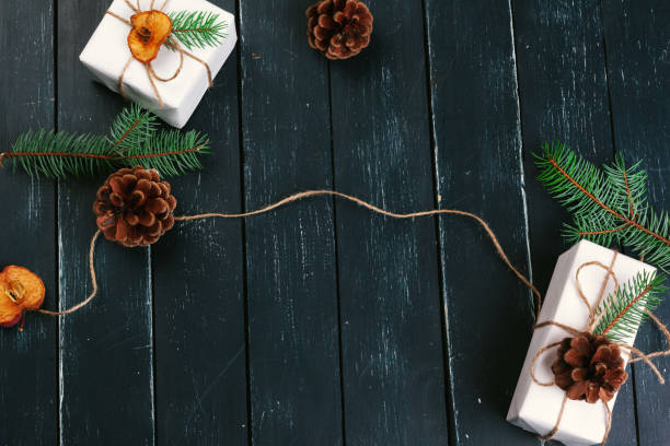 istock Christmas composition. Christmas gift, knitted blanket, pine cones, fir branches on wooden background. 1427683022
