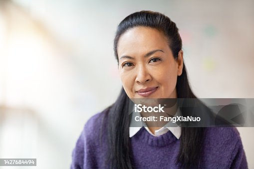istock Portrait of multiracial Asian Hispanic Pacific Islander woman in modern office smiling 1427684494