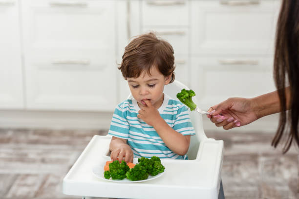 istock The happy child eats broccoli. Organic Cabbage and food on a plate. 1427686331