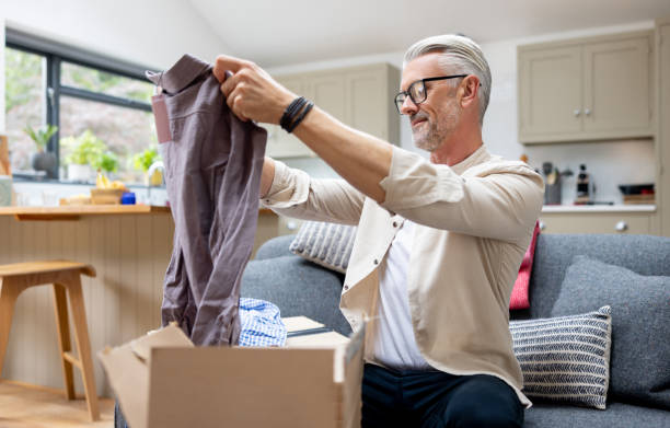 istock Man opening a package at home after shopping online 1427687039