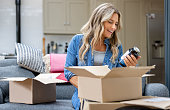 Woman opening a package at home after shopping online