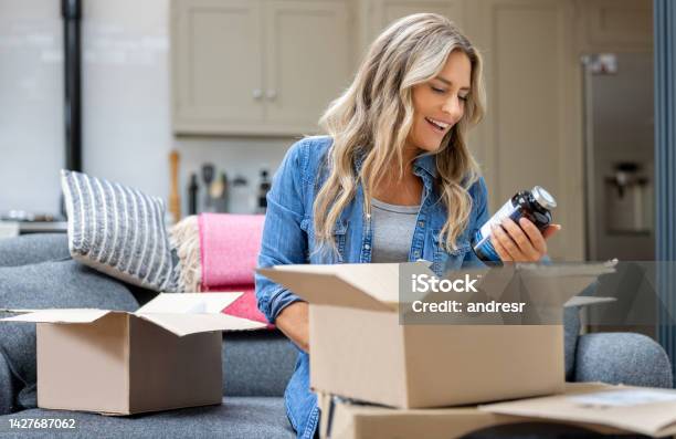 Woman Opening A Package At Home After Shopping Online Stock Photo - Download Image Now
