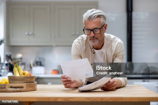 Man At Home Reading A Letter In His Mail Stock Photo - Download Image Now - Mail, Reading, Letter - Document