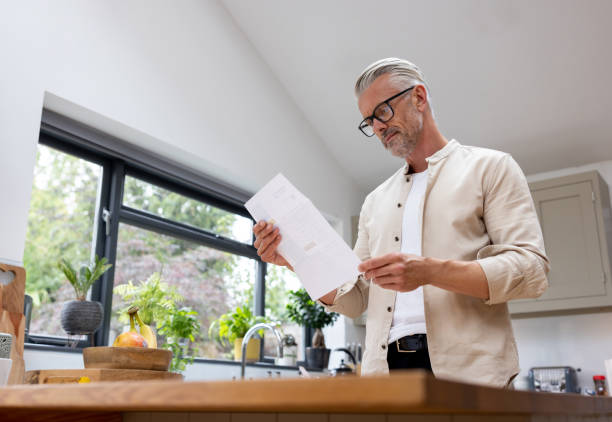 istock Man at home reading one of his utility bills 1427687095