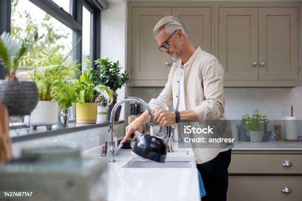 Man Makign A Cup Of Tea And Putting The Kettle On Stock Photo - Download Image Now - Faucet, Boiling, Water
