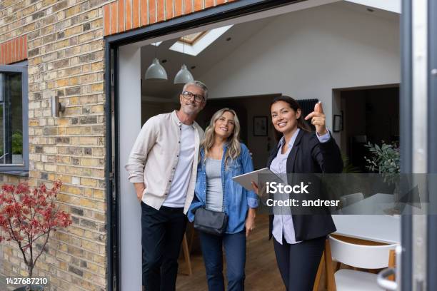 Real Estate Agent Showing A House For Sale To A Couple Stock Photo - Download Image Now
