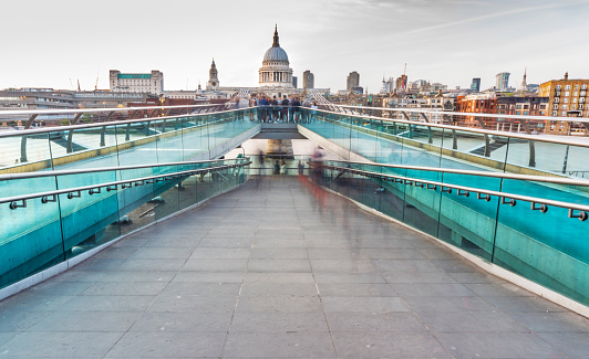 London,England,UK-August 21 2019:Saint Paul's Cathedral protrudes from the top of the famous Bridge,from the north bank of the river Thames,as blurred figures move around at end of a hot summer day.