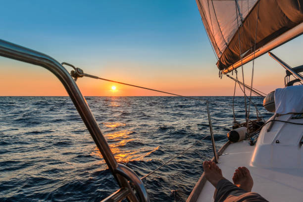 the captain enjoying stretch his feet while the sailboat is on autopilot. - yacht nautical vessel autopilot sailing imagens e fotografias de stock