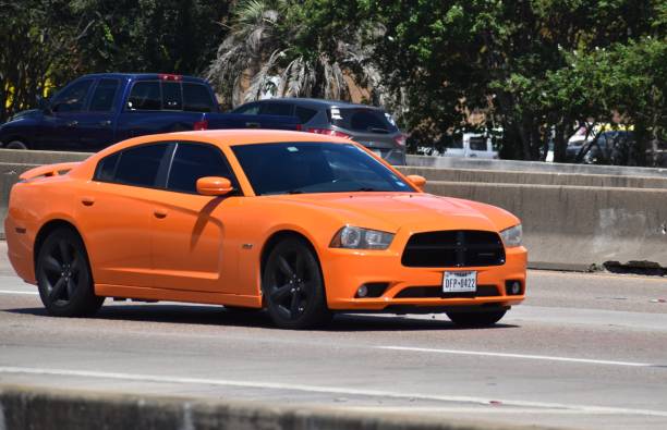 Orange Dodge Charger on Gulf Freeway, Interstate 45 (1-45) in Houston, Tx Orange Dodge Charger cruising on I-45 in Houston, Texas 2022 dodge charger stock pictures, royalty-free photos & images